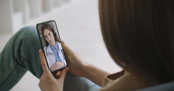 Mulher usando bate-papo on-line para conversar com o terapeuta familiar e verifica possíveis sintomas durante a pandemia de coronavírus. Mulher usando aplicativo médico em consultoria smartphone com médico através de videoconferência. — Vídeo de Stock