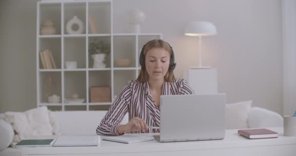 Estudiante mujer está dando examen de lengua extranjera en línea, hablando por chat de vídeo en el ordenador portátil, modo distante — Vídeo de stock