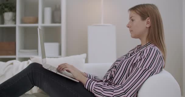 Jovem está conversando na internet em sites de namoro, usando laptop com Wi-Fi em casa para se comunicar — Vídeo de Stock