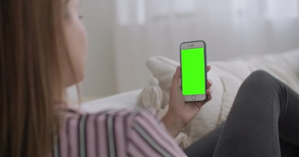 Jovem está transmitindo em rede social por smartphone com tela verde para a tecnologia chroma key, conversando pela internet — Vídeo de Stock