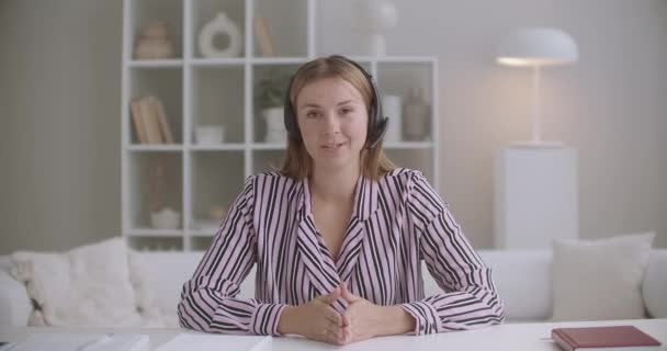 Πορτρέτο της νεαρής γυναίκας που μιλάει στο διαδίκτυο, χρησιμοποιώντας ακουστικά με μικρόφωνο, ενεργό διευθυντή πωλήσεων, που εργάζονται εξ αποστάσεως — Αρχείο Βίντεο