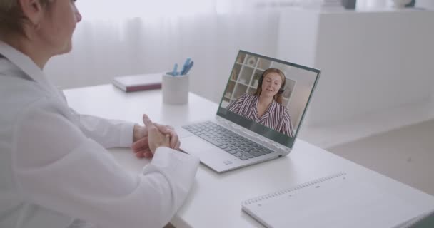 Jovem está consultando on-line com seu médico ginecologista, usando chamada de vídeo pela internet no laptop — Vídeo de Stock