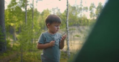 Çocuk babasına ormanda bir çadır kurması ve kurması için yardım ediyor. Çocuklara öğretmenlik yapmak ve çadır kampında birlikte seyahat etmek.