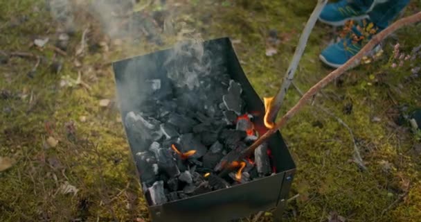 Fermez le plan pour brûler des bâtons sur le feu et jouer avec le feu dans la forêt. Les enfants jouent avec des bâtons brûlants dans les bois — Video