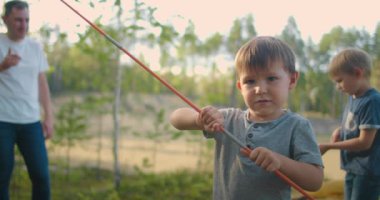 Çocuklar, babalarıyla birlikte gece için bir çadır kurdular ve yolculuk sırasında ormanda kamp kurdular. Bir adam ve iki çocuk, 3-5 yaşlarındayken bir yürüyüş sırasında çadıra çekiliyorlar.