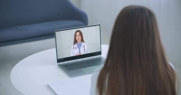 Ramena pohled mladá žena poradenství s rodinou terapeut lékař praktický lékař on-line prostřednictvím videohovoru na notebooku poté, co pocit, první virus nemoci symptomy, zdravotní pojištění, covid19 outspread. — Stock video