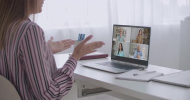 Kadın çalışanın, çeşitli çok ırklı meslektaşlarıyla çevrimiçi brifingde yaptığı video konuşmasında arka planda, kadın çalışanın modern laptopta iş arkadaşlarıyla Webcam grup konferansı var.