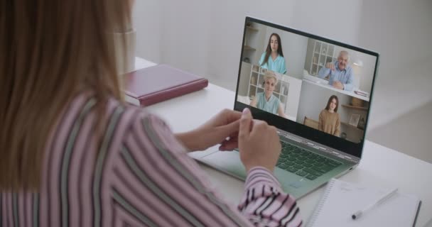 Vue arrière de l'employé féminin parler parler sur appel vidéo avec divers collègues multiraciaux sur le briefing en ligne, travailleuse ont Webcam conférence de groupe avec des collègues sur ordinateur portable moderne à la maison — Video