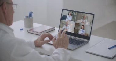 Beyaz önlüklü dört farklı tıp çalışanının vesikalık portresinden bahseden yaşlı doktor, grup video görüşmesine katıldı. Video konferans, konsiyum uzaktan iletişim konsepti