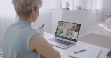 Kadın çalışanın, çeşitli çok ırklı meslektaşlarıyla çevrimiçi brifingde yaptığı video konuşmasında arka planda, kadın çalışanın modern laptopta iş arkadaşlarıyla Webcam grup konferansı var.