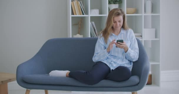 Grappige euforische jonge vrouw klant vieren winnende bod of het krijgen van e-commerce winkelen aanbod op de smartphone. Opgewonden meisje winnaar op zoek naar mobiele telefoon met behulp van app vieren succes concept. — Stockvideo