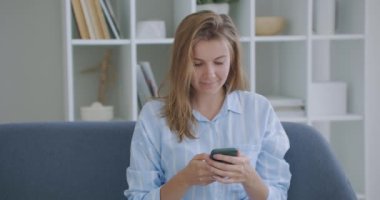 Mutlu bir iş kadını portresi ev telefonunda başarıya ulaşır. Kapalı çekim neşeli kız telefonda iyi haberleri ağır çekimde okuyor. Apartmanda zaferi kutlayan sürpriz kadın..