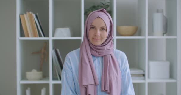 Privind camera și dând din cap, o femeie musulmană într-un hijab vorbește pe un link video și ascultă o prelegere. Conversație video de la distanță — Videoclip de stoc