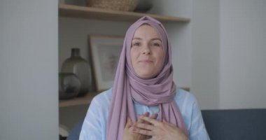 Kameradaki müslüman kıza bakıyorum. Dairelerden arkadaşlarımı arıyorum. Video bağlantısı kuruyorum, el sallıyorum, şık bir odada kanepede oturuyorum.