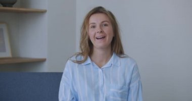 Kıvırcık saçlı genç kadın konuşuyor. İş görüşmesi yapan bir kadın. Genç kız blogger vlogger 'ı çevrimiçi görüntülü konuşma kayıtları arama vlog blogu yapıyor evdeki web kamerasına bakarak kameraya konuşuyor