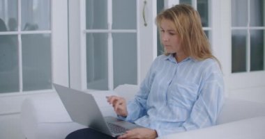 Genç iş kadını rahatla ofis masasında otur dizüstü bilgisayarı bitir ellerini başının arkasına koy işten memnun ol stres rahatlatma konsepti iş yerinde rahatla