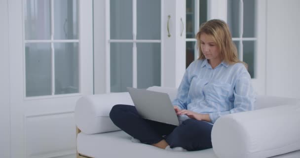 Женщина, работающая дома с ноутбуком. — стоковое видео