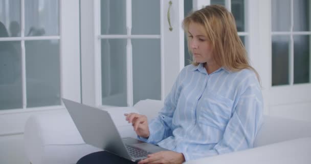 Genç iş kadını rahatla ofis masasında otur dizüstü bilgisayarı bitir ellerini başının arkasına koy işten memnun ol stres rahatlatma konsepti iş yerinde rahatla — Stok video