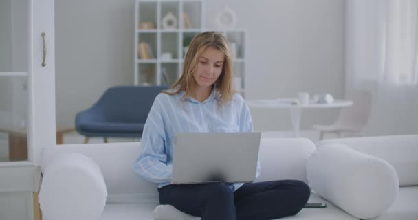 Genç bayan işçi rahatla ofis masasında otur dizüstü bilgisayarı bitir ellerini başının arkasına koy işten memnun ol stres rahatlatma konsepti iş yerinde rahatla — Stok video