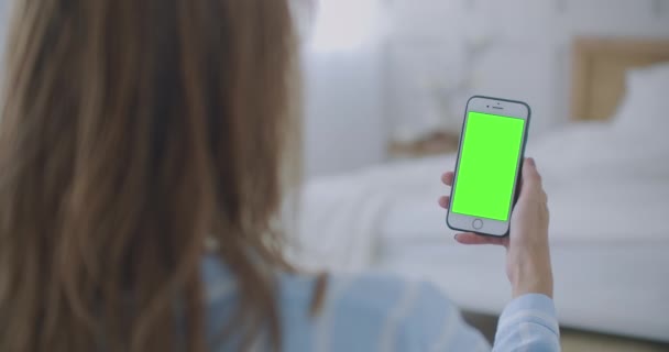 Kvinna Använda och se smart telefon Grön skärm hemma. Ung flicka håller Smartphone med grön skärm på kvällen. — Stockvideo