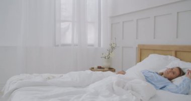 Güzel Esmer Sabah Yavaşça Uyanıyor, Yataktan Geriniyor ve Kalkıyor, Büyük Pencereden Güneş Üzerine Parlıyor. Mutlu Genç Kız Yeni Günü Kutluyor