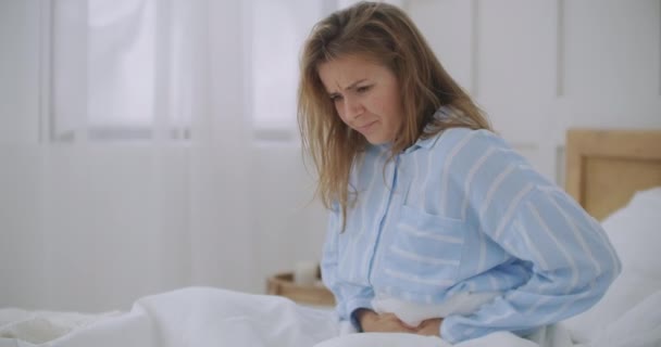 Buikpijn. Het roodharige meisje heeft vreselijke buikpijn bij haar thuis. Buikpijn. Haar menstruatiekrampen zijn te pijnlijk om te gaan werken. — Stockvideo