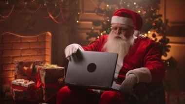 Noel Baba bilgisayardan alışveriş yapıyor. Noel indirimi zamanı.