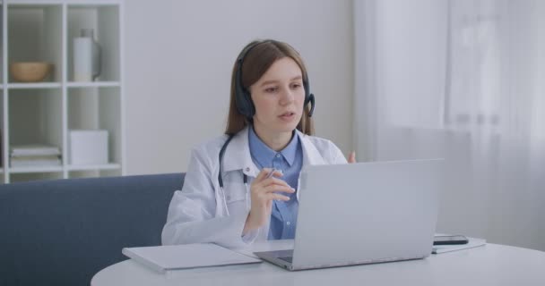 Arztkonsultation per Telefon, Ärztin beantwortet Fragen von Patienten im Call-Center, Profilansicht — Stockvideo