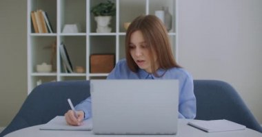 Bilgisayarda araştırma yapan odaklı iş kadını girişimci. Ofis masasında bilgisayar kullanan genç bir bayan profesyonel. Modern teknoloji not defteri üzerinde çalışan meşgul bir işçi.