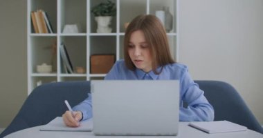 Bilgisayarda araştırma yapan odaklı iş kadını girişimci. Ofis masasında bilgisayar kullanan genç bir bayan profesyonel. Modern teknoloji not defteri üzerinde çalışan meşgul bir işçi.