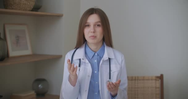 Vänlig kvinnlig läkare hälsar på online chat och börjar online konsultation, frågar och lyssnar patient — Stockvideo