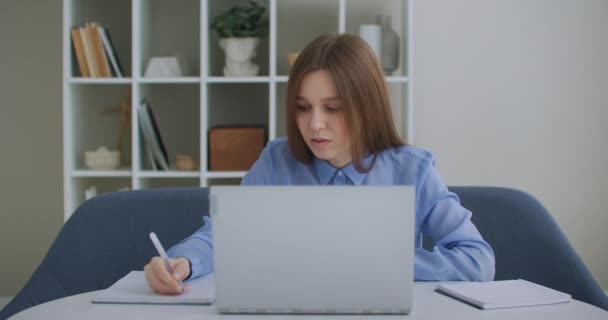 Zaměřený podnikatel, který píše na notebook a dělá výzkum. Mladá profesionálka používající počítač, který sedí u stolu v kanceláři. Rušný pracovník na volné noze pracující na moderním zařízení notebooku — Stock video