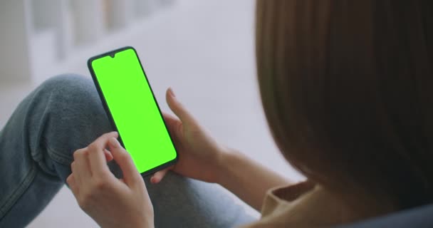 Synpunkt på kvinnan i det moderna rummet Sitter på en stol med hjälp av telefon med grön modell Skärm Chroma Key Surfing Internet Titta på innehåll Videoklipp Bloggar Knacka på Center Screen — Stockvideo