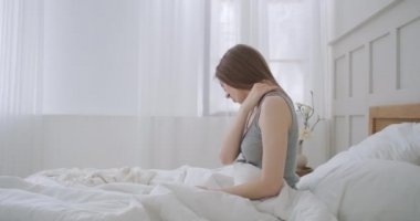 Kadın uyanıyor ve omzunda ve boynunda ağrı var. Bir kadın uyanıyor ve omzunda ve boynunda ağrı var.