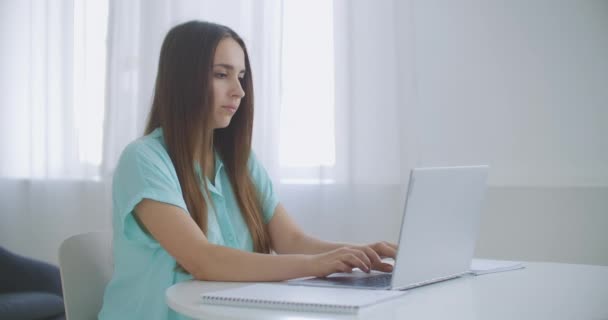 Empresária com laptop em seu escritório na mesa, trabalhando. Mulher de negócios trabalha no computador portátil no contexto de janelas panorâmicas — Vídeo de Stock