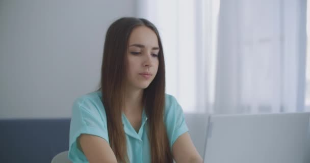 Affärskvinna med laptop i sitt kontor vid skrivbordet, arbetar. Affärskvinna arbetar på bärbar dator på bakgrund av panoramafönster — Stockvideo