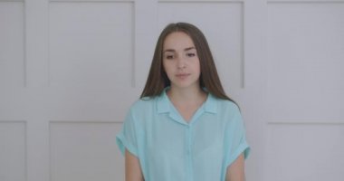 Kadın kameraya bakarken dinliyor ve onaylayarak başını sallıyor. Video arama diyaloğuna katılımcı. Video konferans dinleyicisi evde oturuyor