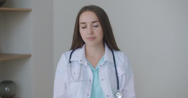 Guardando la macchina fotografica ascolto donna medico guarda la macchina fotografica e ascolta il paziente. Un ascoltatore di videoconferenze. Ritratto di medico — Video Stock