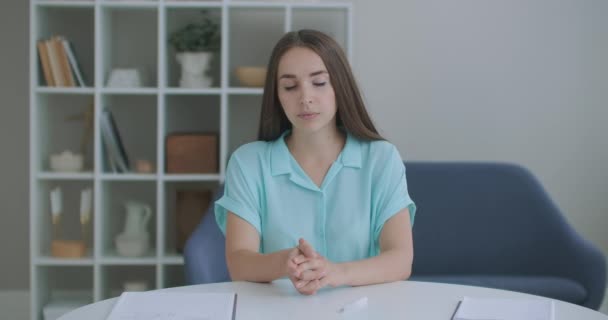 La mujer escucha mientras mira a la cámara y asiente con la cabeza aprobadamente. Participante en el diálogo de videollamada. Videoconferencia oyente sentado en casa — Vídeo de stock