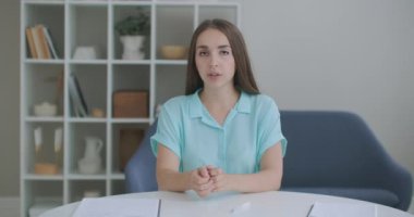 Kameraya bakan fotoğrafçı kadın video görüşmesi yapıyor. Video konferansında çalışan bir bilgisayar ekibinin önündeki kadın.