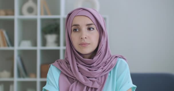 A woman in a hijab looks into the camera and silently nods her head and listens. Conversation via video link. Video conference listen to the doctors recommendations. — Stock Video