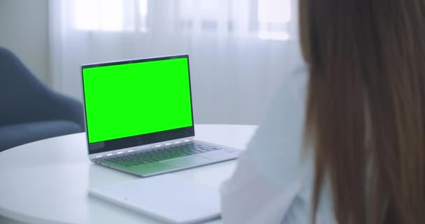 Donna medico sta consultando online, laptop con schermo verde sul tavolo, concetto chiave croma — Video Stock