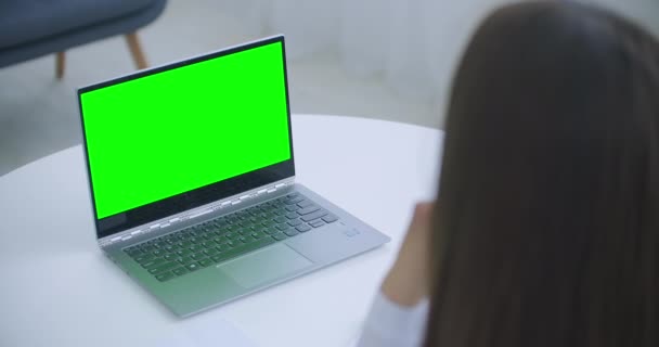 女性医師はオンラインで相談しています,テーブルの上に緑の画面を持つノートパソコン,クロマキーコンセプト — ストック動画