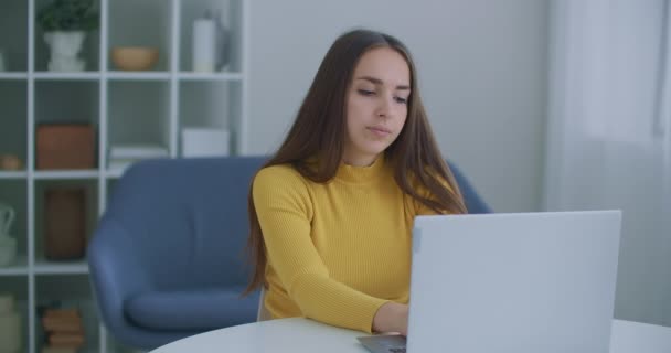 En kvinna som sitter på kontoret värmer ryggen. Ställnings- och ryggproblem när du arbetar vid datorn. Värme och motion när du arbetar på kontoret — Stockvideo