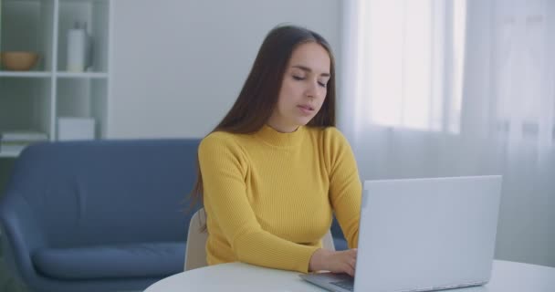 職場で頭痛に悩まされているストレスの多いビジネス女性。片頭痛に対処する疲れ労働者,感情的なストレスの概念は、ノートパソコンとオフィスの机に座って痛みを感じます. — ストック動画