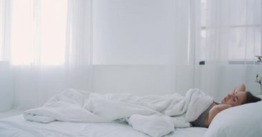 Güzel Esmer Sabah Yavaşça Uyanıyor, Yataktan Geriniyor ve Kalkıyor, Büyük Pencereden Güneş Üzerine Parlıyor. Mutlu Genç Kız Yeni Günü Kutluyor