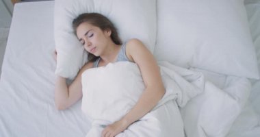 Güzel Esmer Sabah Yavaşça Uyanıyor, Yataktan Geriniyor ve Kalkıyor, Büyük Pencereden Güneş Üzerine Parlıyor. Mutlu Genç Kız Yeni Günü Kutluyor