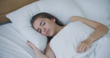 Güzel Esmer Sabah Yavaşça Uyanıyor, Yataktan Geriniyor ve Kalkıyor, Büyük Pencereden Güneş Üzerine Parlıyor. Mutlu Genç Kız Yeni Günü Kutluyor