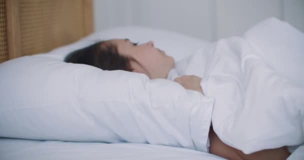 Attraktiv brunett kvinna i pyjamas liggande i sängen sömnlös, sömnlöshet. — Stockvideo
