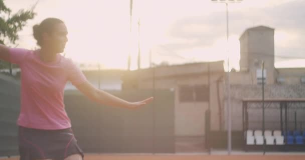 Profesyonel donanımlı kadın tenis raketiyle tenis topuna sert vuruyor. Kadın tenisçi oyun sırasında iş başında. Üzerinde markasız spor giysiler var.. — Stok video